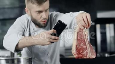 厨师用手机制作肉类照片。 男厨师为牛排拍照。