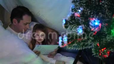 父亲和女儿在圣诞节晚上，在平板电脑上玩和看动画片，在孩子们的房间里`有一个<strong>帐篷</strong>，里面有一个<strong>帐篷</strong>