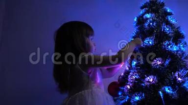 小孩在儿童房的<strong>圣诞树</strong>旁玩耍。 孩子们用圣诞球<strong>装饰圣诞树</strong>。 女儿