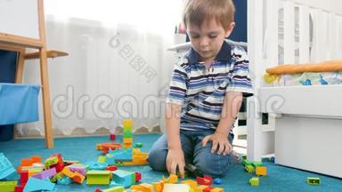 4K小男孩用彩色塑料砖和积木搭建塔的镜头