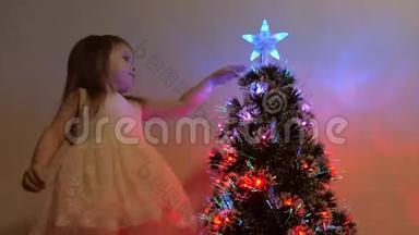 孩子在节日树上检查<strong>一颗</strong>圣诞星。 小女孩在儿童房的圣诞树附近玩耍