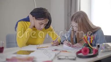 积极的白种人女孩拿着朋友的钢笔微笑。 在室内学习的年轻学生。 生活方式、教育、学习