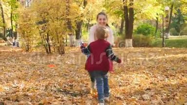 4k<strong>视频</strong>欢快的小男孩跑向年轻的mtoher和<strong>秋天</strong>公园拥抱她