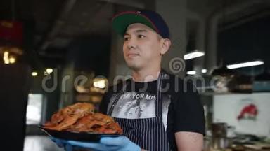 一位戴着帽子的年轻厨师正在一家餐馆里向摄像机展示一盘美味的龙虾，跟踪弧线拍摄，360