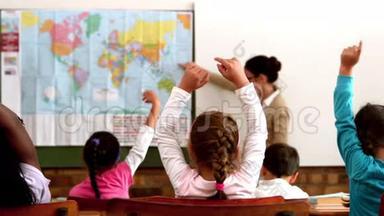 在课堂上的地理课上，小学生举手