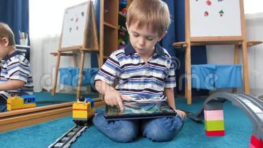 4K小男孩坐在铺有玩具的地毯上的卧室里玩数字游戏的录像