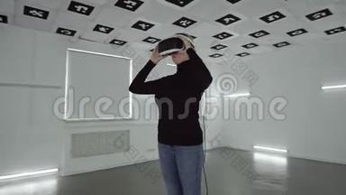 一位年轻的女士戴上了play station虚拟现实耳机，把手臂上下移动，用一个耳机取下耳机
