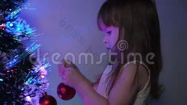 孩子们用圣诞球装饰圣诞树。 特写镜头。 小孩在孩子们`房间里玩圣诞树