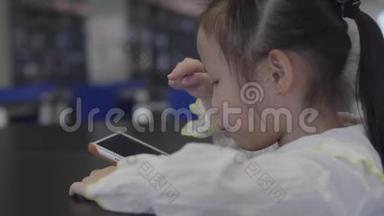亚洲小女孩在家看数码平板电脑上的视频。