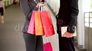 网上购物网站上，女人拿着购物袋在零售购物中心购买产品。 情侣一起买东西
