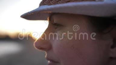 戴帽子的快乐女人欣赏大海的日落，眺望远方，旅行的理念，慢动作
