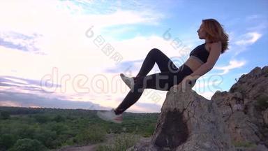 运动的女人在山崖上练习瑜伽和体操，有美丽的景观背景。 健康