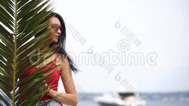 热带棕榈叶的年轻女子。 伤害棕榈叶后面的女人。 <strong>序列</strong>