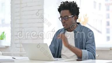 非洲年轻人在笔记本电脑上工作累了