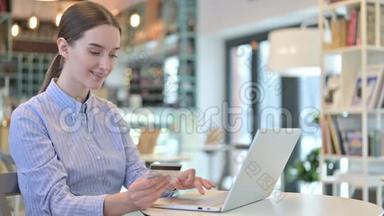 咖啡厅年轻女商人的笔记本电脑在线支付
