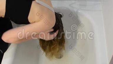一位年轻女子染发后在浴室洗染发剂