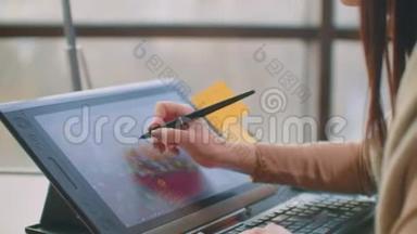 年轻的女<strong>人坐</strong>在她的办公桌<strong>前</strong>，她在画画，写作，用钢笔与数字平板<strong>电脑</strong>。 手拿笔。