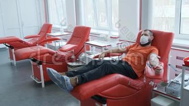 戴面具的捐献者躺在沙发上。 人捐献静脉血.. 献血概念