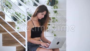 有魅力的漂亮女士集中精力在笔记本上，她坐在商务大楼4k的<strong>楼梯</strong>上