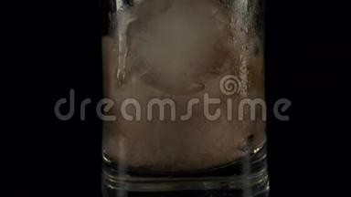 用冰块倒入玻璃杯中的深色可乐。