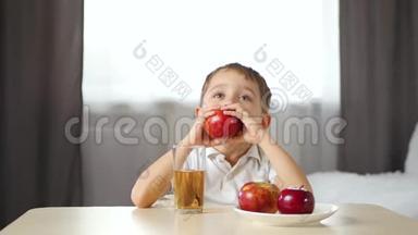 一个快乐的孩子咬掉一片红苹果，竖起大拇指。 儿童健康食品的概念