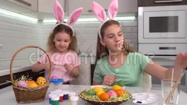 复活节快乐。 两个姐妹画复活节彩蛋。 为复活节做准备的快乐家庭孩子。 可爱的小女孩