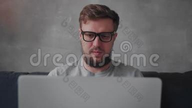 戴眼镜的留胡子的<strong>年轻</strong>人正在笔记本电脑上工作。 自由职业。