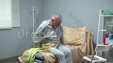 医生帮助老人坐在<strong>医院的</strong>轮椅上