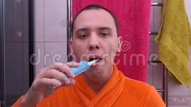 卫生间用<strong>电动牙刷</strong>刷牙的人。