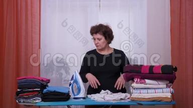 女人累了在家里熨衣服。 女人`不喜欢熨烫。