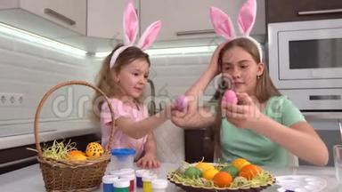 复活节快乐。 两个姐妹画复活节彩蛋。 为复活节做准备的快乐家庭孩子。 可爱的小女孩