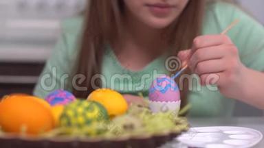 复活节快乐。 女孩画复活节彩蛋。 为复活节做准备的快乐家庭孩子。 可爱的小女孩穿着