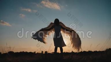 日落时分，一个穿着天使翅膀在草地上旋转的女孩