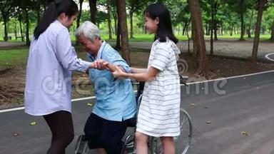 亚洲孙女女儿支持，帮助高年级妈妈从轮椅上站起来练习<strong>走路</strong>，快乐的老年病人w