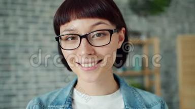 戴着眼镜的年轻漂亮黑发女子<strong>独自在家</strong>微笑的特写照片