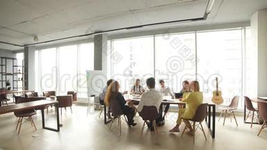 宽敞的办公室有全景窗口，有一群<strong>公司员工</strong>一起<strong>工作</strong>和休息。
