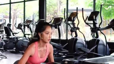 在健身俱乐部工作期间，坚定而严肃地积极参加运动的亚洲女运动员<strong>蹲着</strong>药球