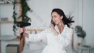 穿着<strong>白色浴袍</strong>跳舞、唱歌、吹干头发的年轻女子