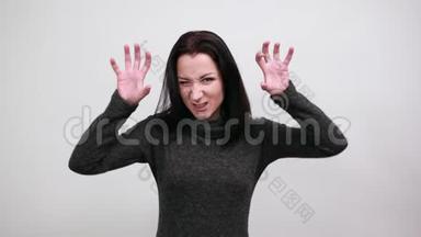 疯狂的女人在镜头前做动物手势，露出手掌，露出舌头