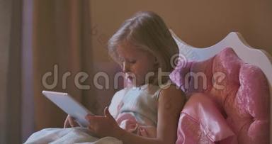 白人女孩躺在平板电脑旁睡觉。 <strong>漂亮</strong>的孩子在粉红色的床上睡着了。 在家休息