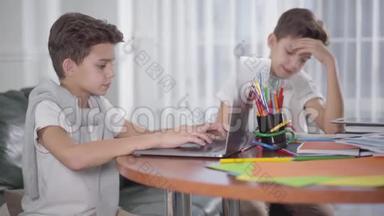 年轻白种人男孩使用笔记本电脑作为他的孪生<strong>兄弟</strong>在后台写作的肖像。 <strong>兄弟</strong>姐妹一起学习