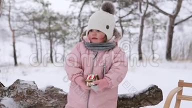 小<strong>可爱</strong>的女孩站在雪地冬季公园里<strong>吃</strong>圣诞姜饼。 <strong>可爱</strong>的<strong>宝宝</strong>穿着温暖的粉红色时尚