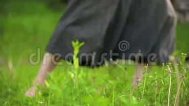 一个练习者在户外草地上`腿的特写。 在气功练习中赤脚穿越。 a的概念
