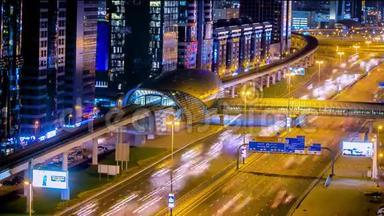 地铁车站与交通在高速公路夜间时间推移在迪拜，阿联酋。 迪拜地铁沿谢赫扎耶德行驶40公里