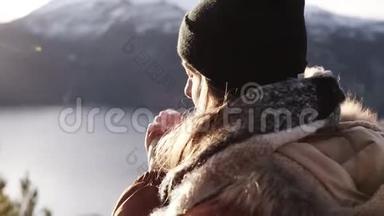 冬日里穿着外套的微笑女人在冬日里特写，肖像直勾勾地望着<strong>天边</strong>，背景令人惊叹