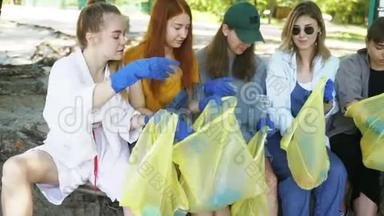 一群积极分子朋友把垃圾分类成袋子。 环境保护。