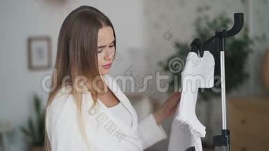 年轻女子穿着白色浴袍，在家穿着带蒸笼的t恤衫