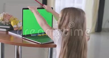 白人女孩用绿色屏幕看笔记本<strong>电脑</strong>的<strong>背面</strong>视图。 在网上学习或使用社交媒体或