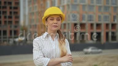自信的女建筑师戴着安全帽看着镜头，双臂交叉在<strong>胸前</strong>。 4K