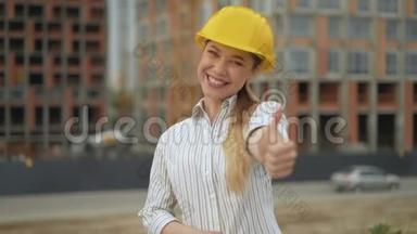 <strong>竖</strong>起大拇指！ 微笑快乐的女建筑师戴着安全帽，看着相机，<strong>竖</strong>起大拇指。 4K